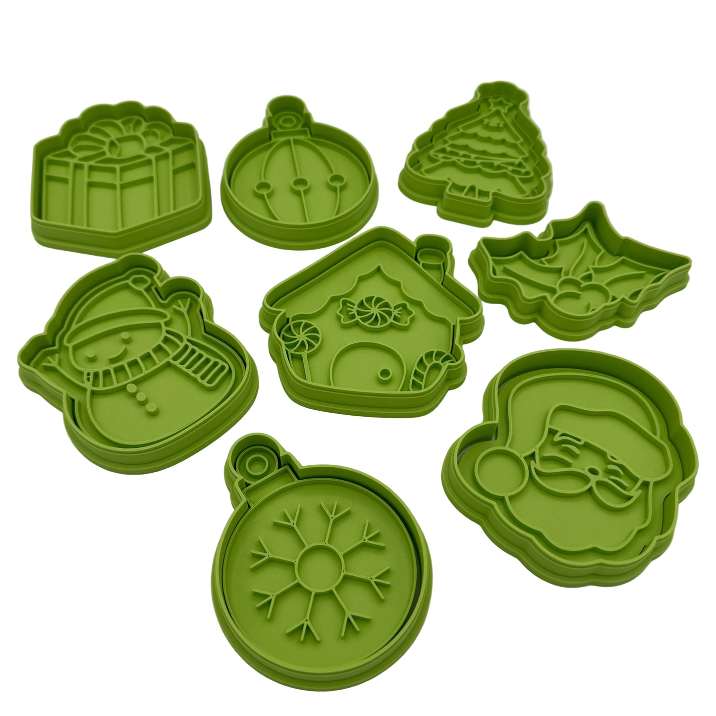 Set of Christmas cookie cutters and press including shapes like Santa, snowflake ornament, wreath, tree, gift, and holly.