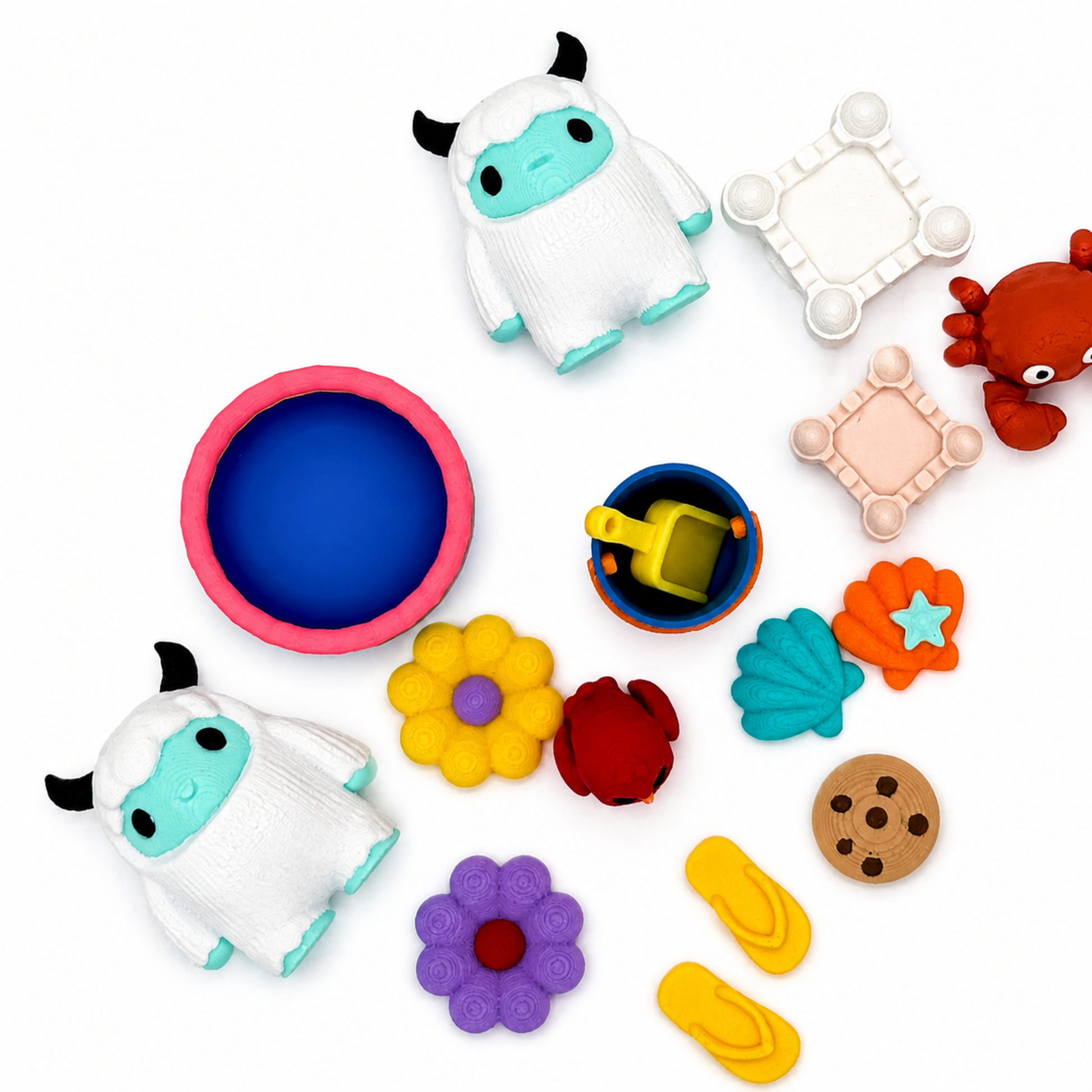 Close-up overhead view of the Yeti & Friends sensory play set highlighting detailed 3D printed miniature yetis, beach toys, owl, crab, stars, flowers, and storytelling accessories.