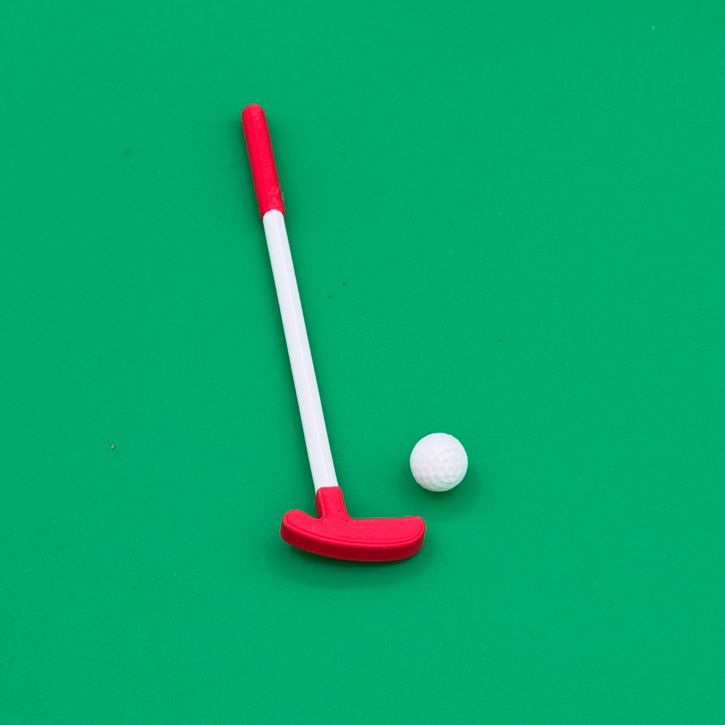 Closeup view of tiny golf putter and ball