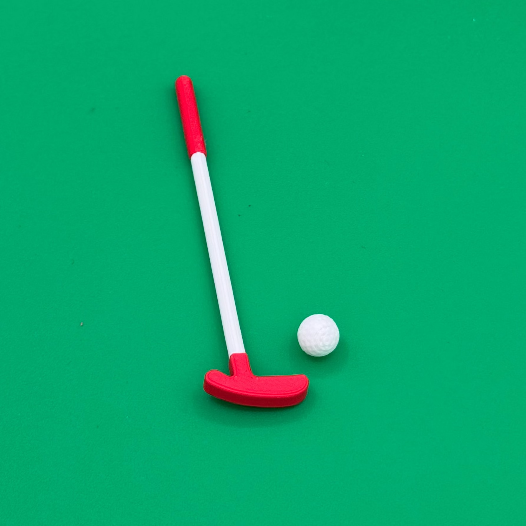 Closeup view of tiny golf putter and ball