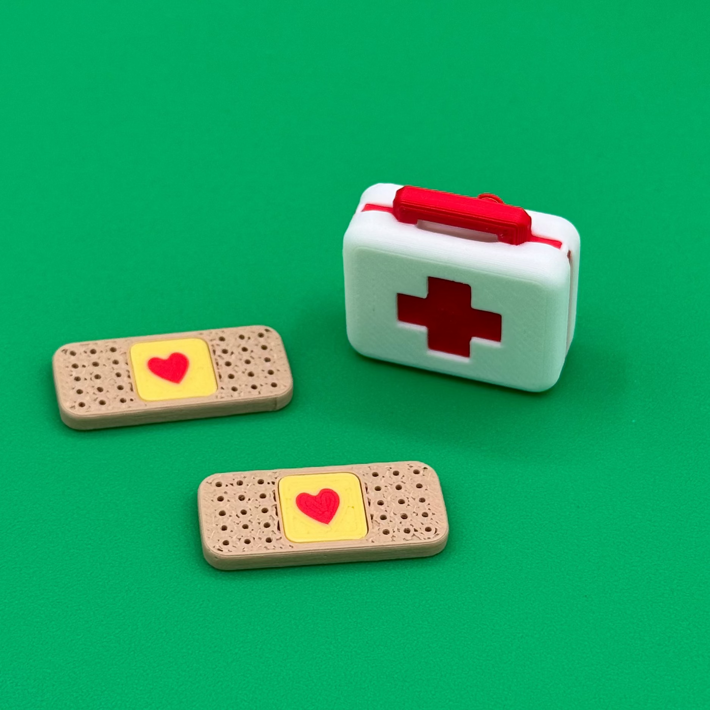Miniature first aid kit and bandages on a green background