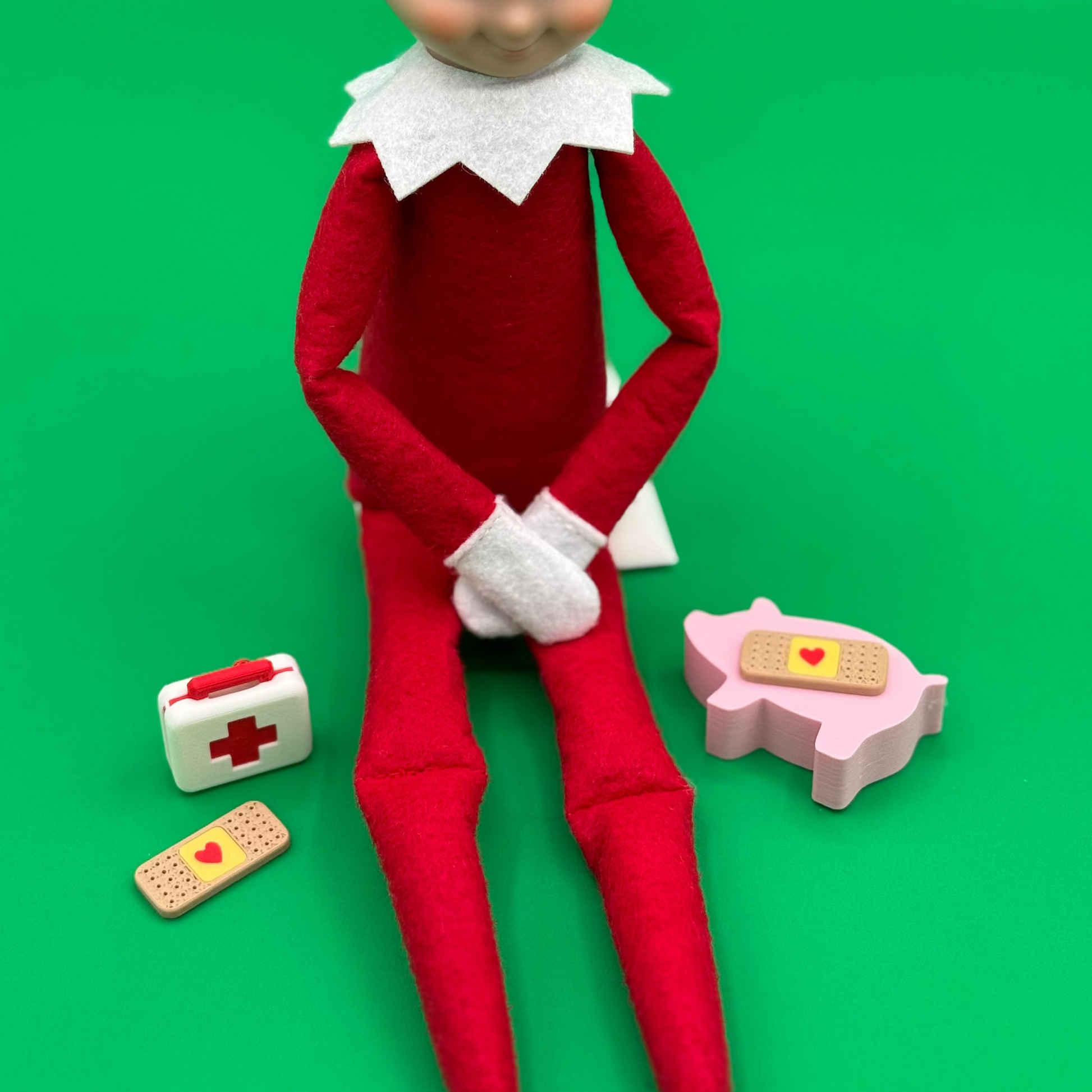 Elf on the Shelf with medical supplies on a green background