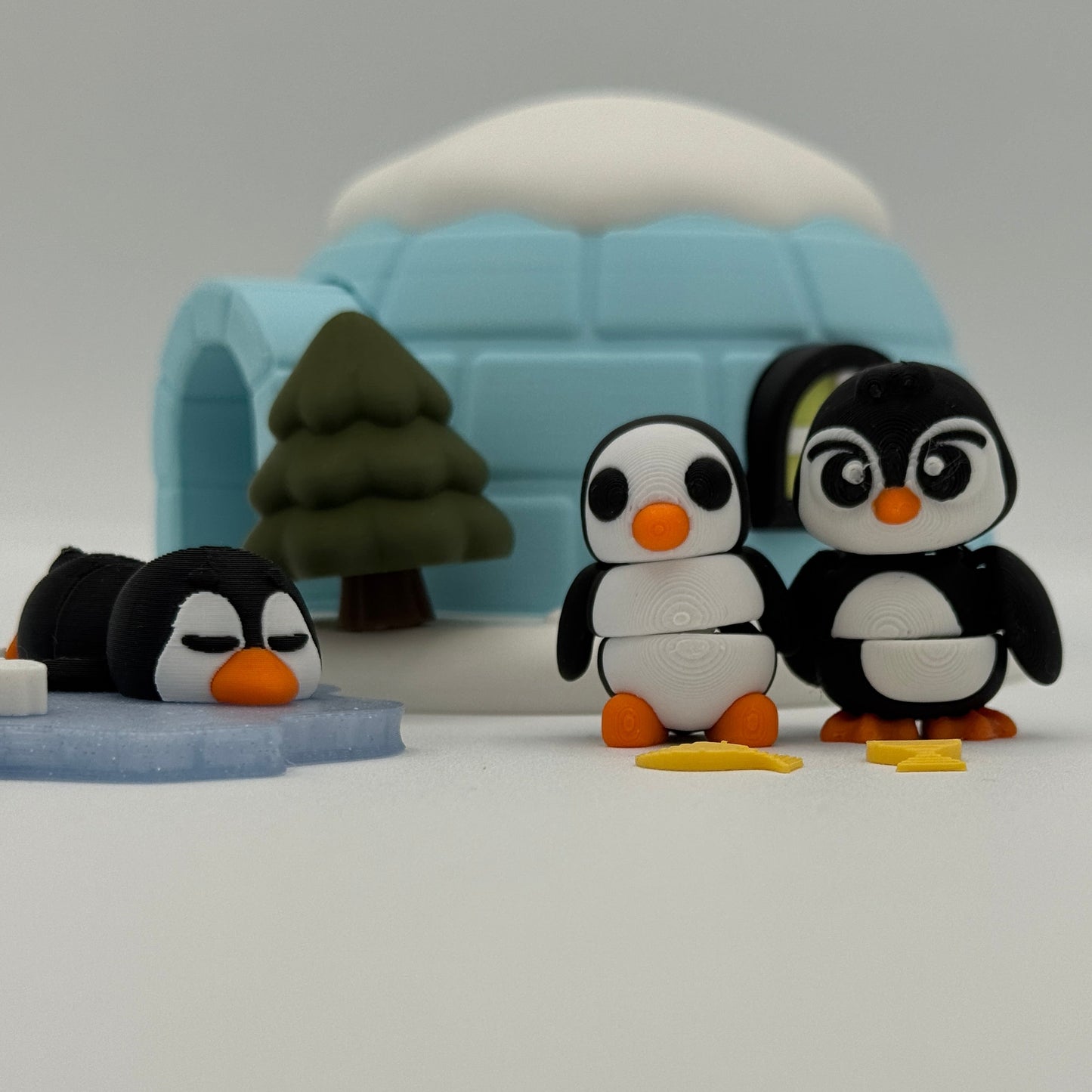 3D printed penguin characters outside an igloo for winter storytelling and pretend play