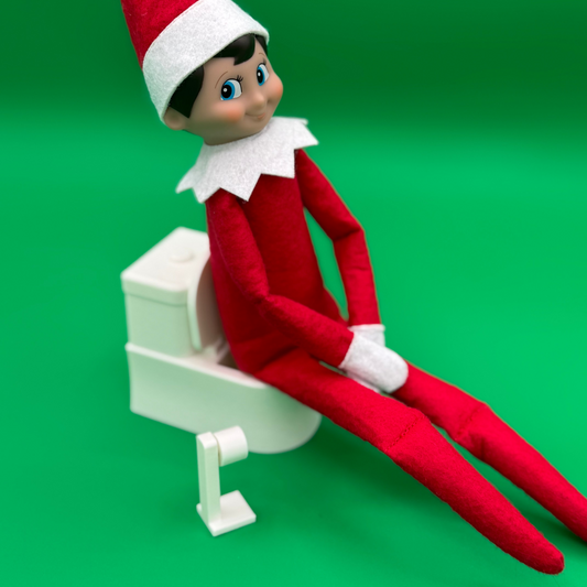 Elf sitting on miniature toilet prop