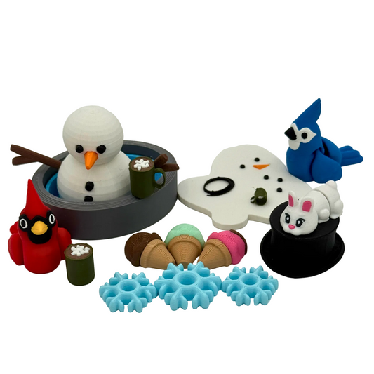3D printed winter storybook character set featuring snowman figures, animal friends, and small winter accessories arranged for guided play and storytelling