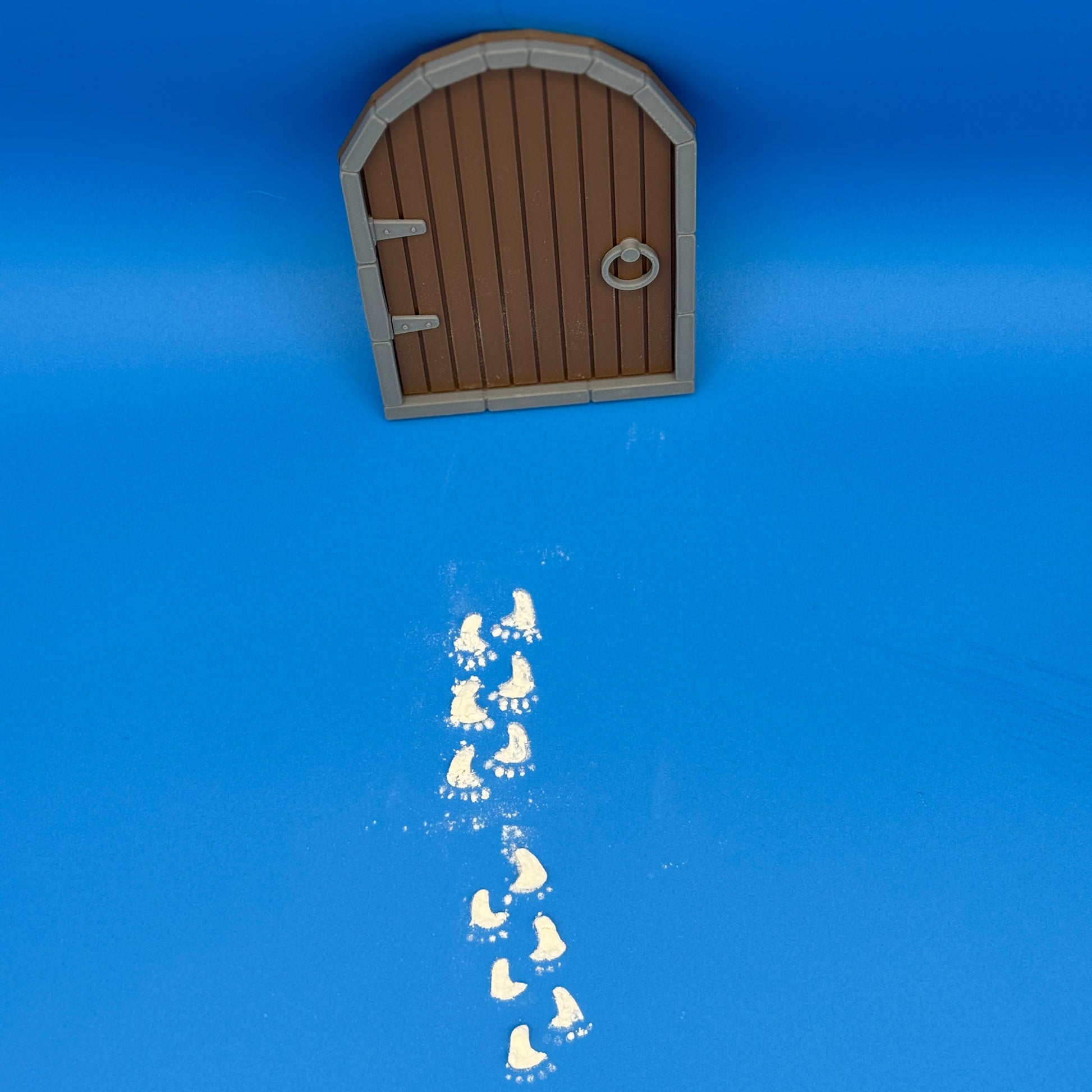 Rustic brown elf door with flour footprints made using matching 3D printed stencil