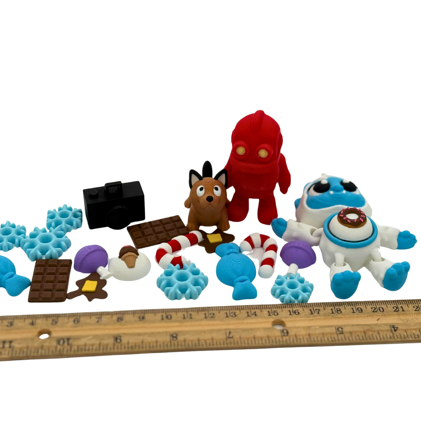 BriteBerry storybook miniatures displayed beside a ruler to show approximate size, including clickable tummy yeti, robot, dog, and winter-themed accessories
