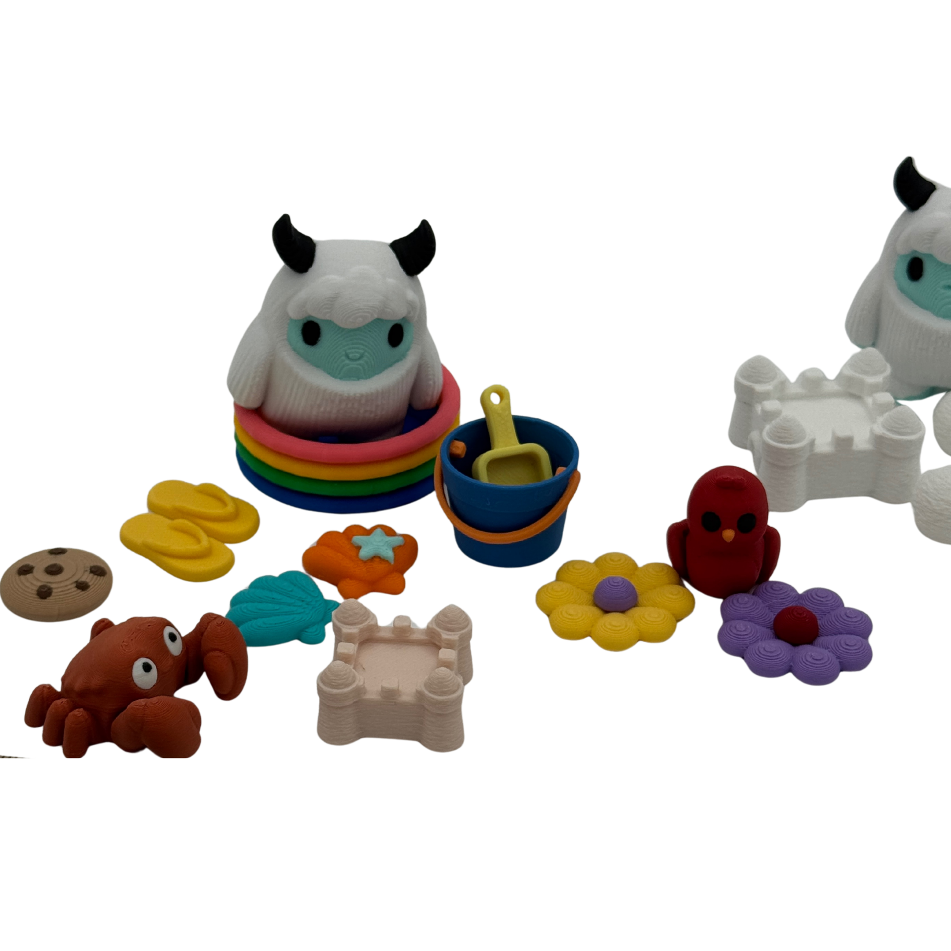 Close-up view of 3D printed yeti figures and small accessories showing detail and texture